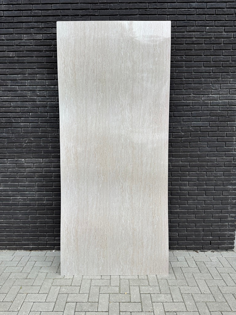 PVC-wandpaneel Travertine Beige tegen een zwarte muur met zichtbare glans